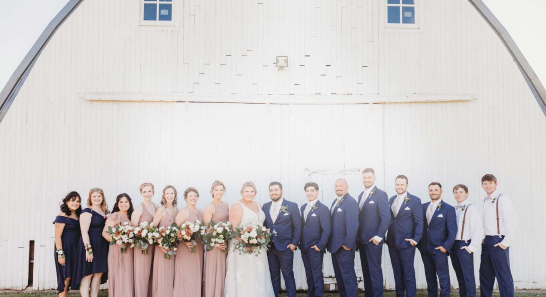 Bride and Groom with their wedding party in front of the Rustique Barn, the Top Wedding Venue in Delano, MN.